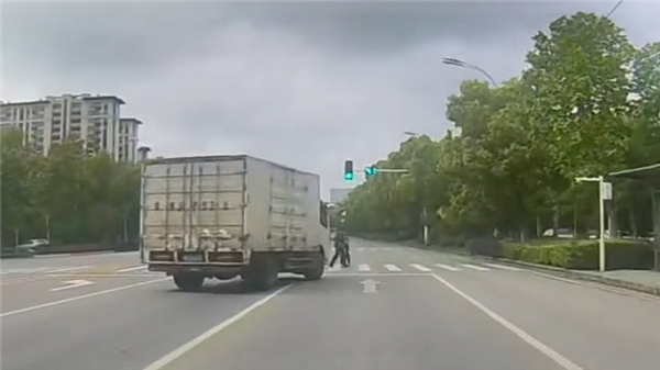 路口绿灯亮起货车突然压线“别车” 网友反手怒赞