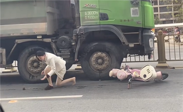 “死亡弯月”盲区太可怕!渣土车撞倒电动车 幸运女子从车底爬出