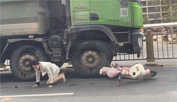 “死亡弯月”盲区太可怕!渣土车撞倒电动车 幸运女子从车底爬出