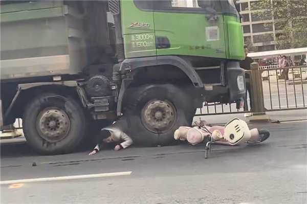 “死亡弯月”盲区太可怕!渣土车撞倒电动车 幸运女子从车底爬出